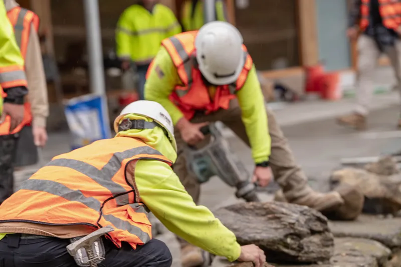 Crew resetting capstones on a fieldstone wall