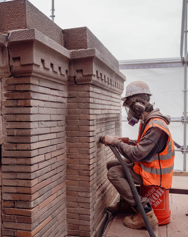 Cutting out mortar joints with a vacuum-attached grinder